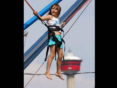 Peyton Herbert, 7, jumps sky high on the bungee swing at the Calgary Stampede Kids Midway on July 10, 2015.