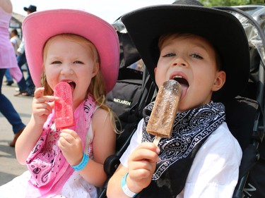 Victoria Commandant and her brother Kingston cool of with popsicles on the Calgary Stampede midway on July 10, 2015.
