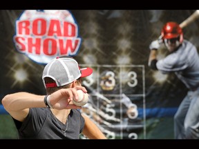 Brett Dietterle tries out the pitching area at Major League Baseball Road Show exhibit at the Calgary Stampede on July 10.