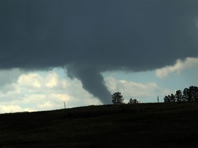 A funnel cloud is seen over the city from Nose Hill on July 22.
