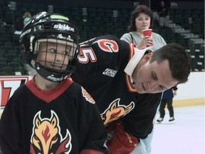 Martin St. Louis, right, signs the jersey of young hockey player Austin Cowley in June 2000. Later that summer, he was released from the Flames and went on to a Hall of Fame-calibre career with Tampa Bay and New York.