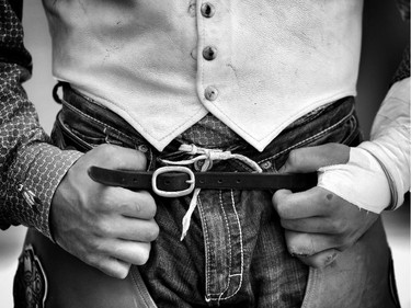 Bareback rider Ty Taypotat's beat up hands before his ride at the Calgary Stampede on july 4, 2015.