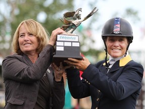 Shelia McIntosh, left, vice president environment and corporate affairs at Cenovus Energy, presents American Leslie Howard  with the trophy at the $200,000 Cenovus Energy Classic Derby on Sunday, the final event of the Spruce Meadows' North American tournament