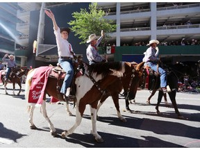 Premier Rachel Notley waves to spectators during the Calgary Stampede parade on Friday.