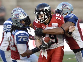 Calgary Stampeders quarterback Bo Levi Mitchell is sacked by Montreal Alouettes' Darrin Kitchens (72) and John Bowman (7) during Friday's game. The Stamps lose 29-11 and vow not to get outplayed like that again.