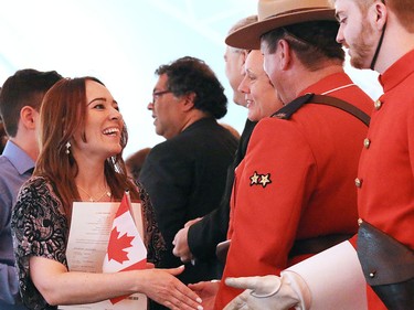 New Canadians shake hands with politicians, RCMP and Heritage Park staff in a Canada Day citizenship ceremony at Heritage Park.