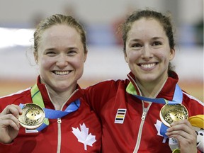 Canada's Kate O'Brien, left, and Monique Sullivan pose for photos with their gold medal earned at the women's team sprint track cycling competition at the Pan Am Games in Milton, Ontario, Thursday, July 16, 2015.