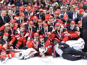 Canadian players and officials pose with the trophy as they celebrate their 5-4 win over Russia during the gold medal game hockey action at the IIHF World Junior Championship in Toronto on Monday, Jan. 5, 2015.