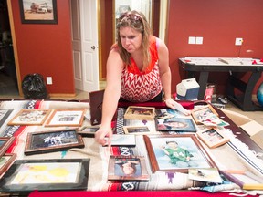 Jodie Hassett looks at framed photos on a pool table in the family's flooded basement on Cavendish Beach Bay in Chestermere.