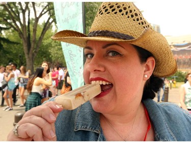 Gwendolyn Richards tries the mini donut popsicle for a great twist at the Calgary Stampede in Calgary, on July 6, 2015.
