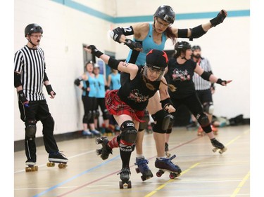 Christina Ryan/ Calgary Herald CALGARY, Alberta --JULY 29, 2015 -- Jammer LaneSplitter balances on one skate after avoiding a hit from Cut-Throat Car Hops blocker Easy Break Oven (in teal) in a Calgary Roller Derby Association scrimmage, on July 16, 2015. (Christina Ryan/Calgary Herald) (For {sup 1} story by {cart}) 00066623A SLUG: 9999 Roller Derby 8