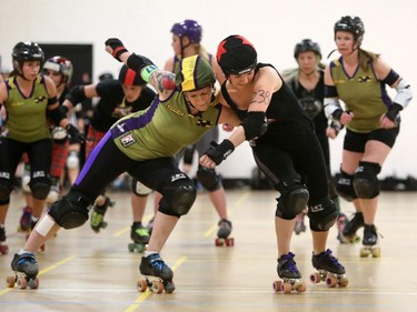 Christina Ryan/ Calgary Herald CALGARY, Alberta --JULY 29, 2015 -- Knox Hersoxoff of the B-52 Bellas (in green) tries to block wily Thrashin' Lassies jammer Preacher's Slaughter (in black) during a Calgary Roller Derby Association scrimmage, on July 16, 2015. (Christina Ryan/Calgary Herald) (For {sup 1} story by {cart}) 00066623A SLUG: 9999 Roller Derby 7