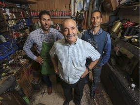 Sam Alain, a cobbler and owner of Capital Hill Shoe Clinic, poses for a photo with his sons, Sam Jr., left, and Danny, right, who are following in his cobbling footsteps, at the store's workshop, hidden away behind the food court at Marlborough Mall in Calgary, on July 9, 2015.