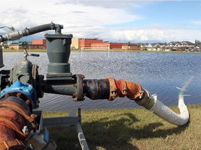 A large pump was set up to help lower the storm pond water levels behind St. Gabriel the Archangel School in Chestermere on July 16, 2015. Pumps had been installed in various places in the City of Chestermere in preparation for more rain on Friday.