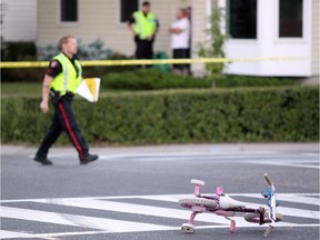 Police investigate after a woman and two toddlers were struck while crossing Temple Drive at 56th Street N.E. just after 8 p.m. on Wednesday, July 29, 2015.