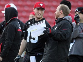 Calgary Stampeders offensive co-ordinator Dave Dickenson, right, speaks with quarterback Bo Levi Mitchell about a play last November. He is preaching calm and patience with Calgary's sputtering offence.