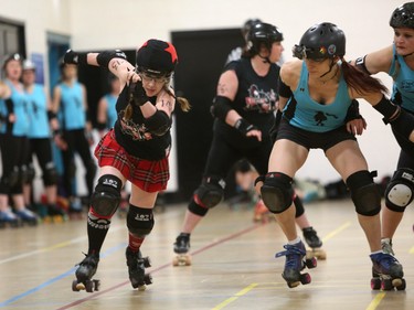 Thrashin’ Lassies jammer LaneSplitter takes the outside lane to escape the pack and get into point scoring position during a Calgary Roller Derby Association scrimmage.