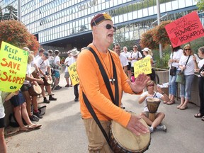 Roger Duncan of the Save The Slopes group plays bongos to inspire his people Sunday July 18, 2015 during a protest at City Hall. The group is trying to stop a large development adjacent to Canada Olympic Park on the Paskapoo Slopes.