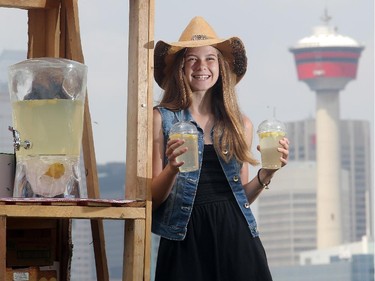 Thirteen year old entrepreneur Alina Moore holds up the lemonade she is selling from her stand overlooking the Stampede grounds from the front lawn of her family's Ramsay home Tuesday July 8, 2015. She says she is donating a portion of the proceeds to the Calgary Humane Society. It's her fourth year in the front lawn lemonade business.