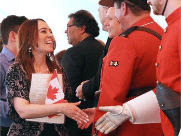New Canadians shake hands with with politicians, RCMP and Heritage Park staff in a Canada Day citizenship ceremony at Heritage Park.
