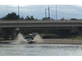 A 4x4 truck drives through the Bow River near the Graves Bridge boat launch on July 19, 2015.