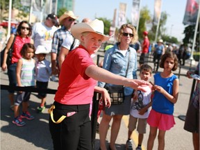 Calgary Stampede employee Nina Garrett helps guide guests at the north entrance to Stampede Park on Thursday July 9, 2015.