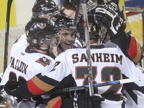 Hitmen defenceman Jake Bean, centre, has seen his hockey career on an upward arc, recently being named to the NHL's Central Scouting futures list entering his draft year.