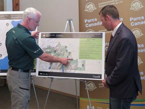 Waterton Lakes National Parks superintendent Ifan Thomas and Macleod MP John Barlow look at maps of the new infrastructure improvements in Waterton Lakes National Park.