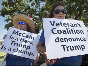 Lourdes Galvan, left, and Irma Vargas, both of San Antonio, Texas, hold signs denouncing Republican presidential contender Donald Trump, Thursday, July 23, 2015, at Laredo International Airport in Laredo, Texas.