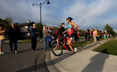 A competitor grabs her bike after finishing the swim portion of  the Ironman 70.3 Calgary at Auburn Bay on July 26, 2015.