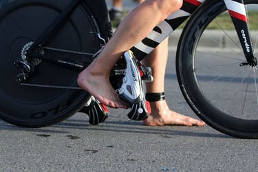 Athletes get on their bikes after finishing the swim portion of  the Ironman 70.3 Calgary at Auburn Bay on July 26, 2015.