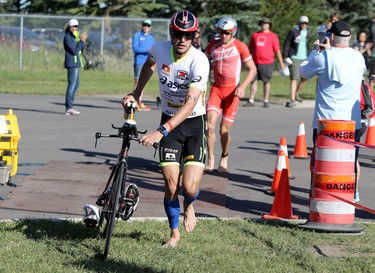 Andy Potts runs into the bike to run transistion during the Ironman 70.3 Calgary at Auburn Bay on July 26, 2015.