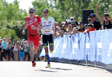 Andy Potts, right and Ben Hoffman, left neck in neck to the finish line during the Ironman 70.3 Calgary at Auburn Bay on July 26, 2015.