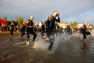 Athletes take to the water during the start of the Ironman 70.3 Calgary at Auburn Bay on July 26, 2015.