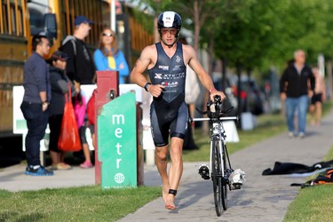 A competitor grabs his bike after finishing the swim portion of  the Ironman 70.3 Calgary at Auburn Bay on July 26, 2015.