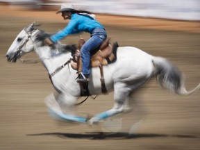 Julie Leggett, from Kamloops, B.C., competes in the barrel racing event at the Calgary Stampede on Sunday. Anti-rodeo activism is a latent attack on rural Canadians and western culture, writes Graeme Menzies.