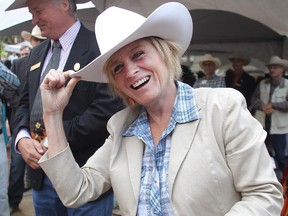 Premier Rachel Notley tips her Smithbilt after getting white-hatted by Calgary Stampede president and chairman of the board Bill Gray at the annual Premier's Stampede Pancake Breakfast at McDougall Centre on Monday, July 6, 2015.