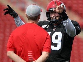 Calgary Stampeders quarterback Bo Levi Mitchell goes over strategy with offensive co-ordinator Dave Dickenson during practice Friday July 10, 2015 in advance on Monday's game against Toronto.