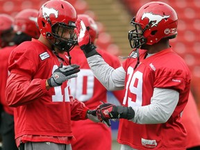 Calgary Stampeders linebacker Juwan Simpson, left, and defensive lineman Charleston Hughes had a little fun with a special handshake during practice with teammates at McMahon Stadium on July 16, 2015.