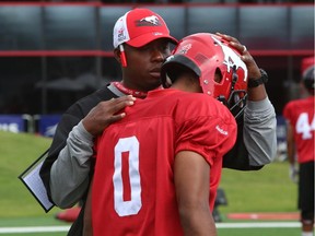 Calgary Stampeders defensive back coach Kahlil Carter talks to Ciante Evans, during practice on Wednesday.