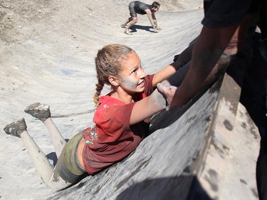 Jodene Vercuiel is pulled by family up the Warped Wall at the Rugged Maniac run Saturday July 17, 2015 at Rocky Mountain Show Jumping. Hundreds of adventurers ran, climbed and slogging through a 5 kilometre course of ropes, towers, mud and fire. The show travels across North America with it's next Canadian stop in Vancouver August 15.