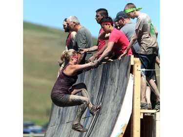 Competitors are pulled up the Warped Wall at the Rugged Maniac obstacle course Saturday July 18, 2015 at Rocky Mountain Show Jumping. Hundreds of adventurers ran, climbed and slogging through a 5 kilometre course of ropes, towers, mud and fire. The show travels across North America with it's next Canadian stop in Vancouver August 15.