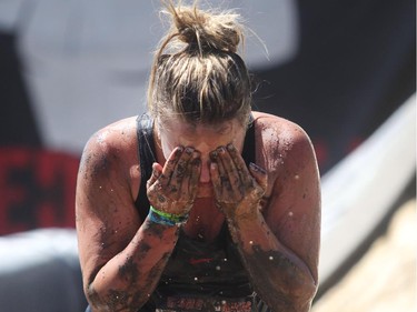 Rachel Atssion wipes a healthy dose of mud out of her eyes after the Accelerator mud slide portion of the Rugged Maniac run Saturday July 17, 2015 at Rocky Mountain Show Jumping. Hundreds of adventurers ran, climbed and slogging through a 5 kilometre course of ropes, towers, mud and fire. The show travels across North America with it's next Canadian stop in Vancouver August 15.