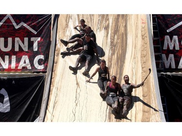 A group holds hands and take a selfie as they take on the Accelerator mud pit slide on the Rugged Maniac obstacle course Saturday July 18, 2015 at Rocky Mountain Show Jumping. Hundreds of adventurers ran, climbed and slogging through a 5 kilometre course of ropes, towers, mud and fire. The show travels across North America with it's next Canadian stop in Vancouver August 15.