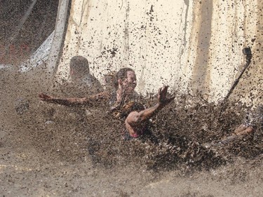 A group plashes down at the bottom of the Accelerator mud pit slide on the Rugged Maniac obstacle course Saturday July 18, 2015 at Rocky Mountain Show Jumping. Hundreds of adventurers ran, climbed and slogging through a 5 kilometre course of ropes, towers, mud and fire. The show travels across North America with it's next Canadian stop in Vancouver August 15.