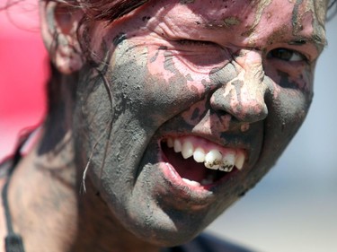 Jessica Larson with a mud splattered grin during the Rugged Maniac run Saturday July 17, 2015 at Rocky Mountain Show Jumping. Hundreds of adventurers ran, climbed and slogging through a 5 kilometre course of ropes, towers, mud and fire. The show travels across North America with it's next Canadian stop in Vancouver August 15.