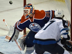 Edmonton Oilers goalie Ben Scrivens (30)  makes the save on Winnipeg Jets Michael Frolik (67) during NHL action at Rexall Place in Edmonton, March 23, 2015.