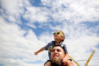 Jeremy Vigini and his son Riley, 4, look to the skies during the Wings Over Springbank air show at Springbank Airport west of Calgary on July 19, 2015.