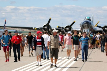 Crowds on the main runway with a WW II b-17 bomber Sentimental Journey in the background during the Wings Over Springbank air show at Springbank Airport west of Calgary on July 19, 2015.