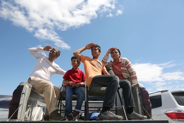 Tahir Jamil and his wife Sobia with their boys Hayyan, 7, left and Hassan, 11, right, look to the skies during the Wings Over Springbank air show at Springbank Airport west of Calgary on July 19, 2015.